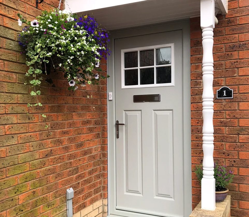 A white door with four panes and a flower pot.